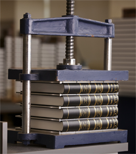 Livres plac&eacute;s dans une presse &agrave; reliure