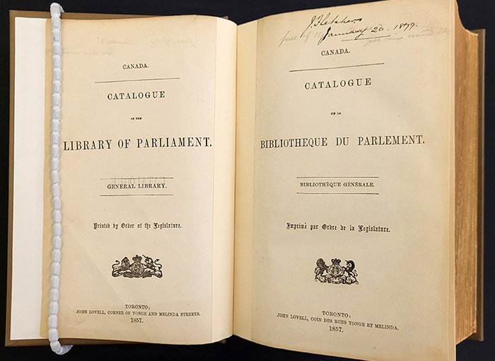 Livre ouverte, montrant les pages titres bilingues du Catalogue de la Bibliothèque du Parlement de 1857.